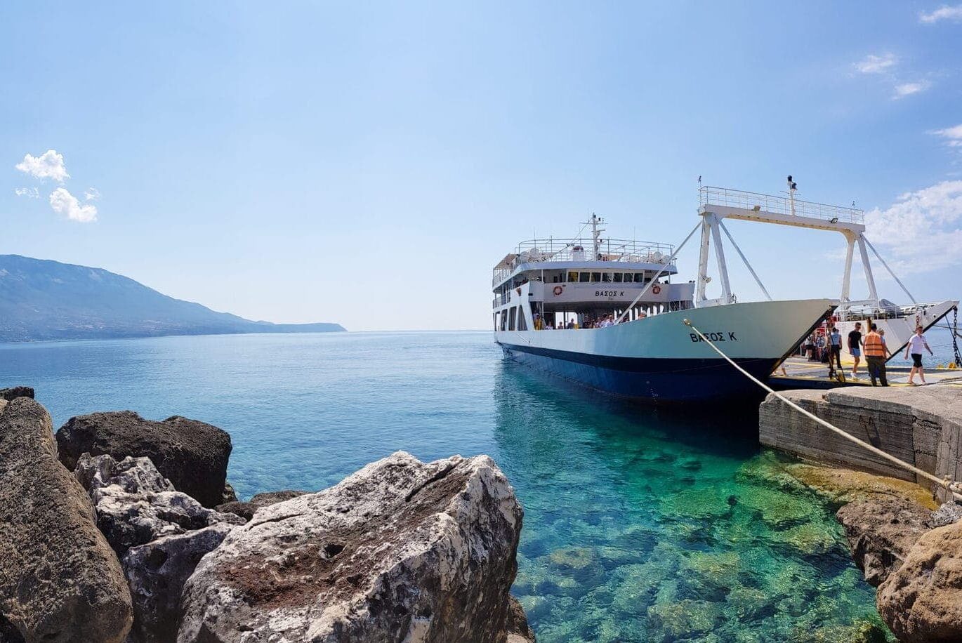 Prom na Kefalonię z Zakynthos, port Pessada (Kefalonia) z górą Ainos po lewej i zakotwiczony prom po prawej, w letni słoneczny dzień, podczas wycieczki lokalnej na Zakynthos z przewodnikiem po polsku