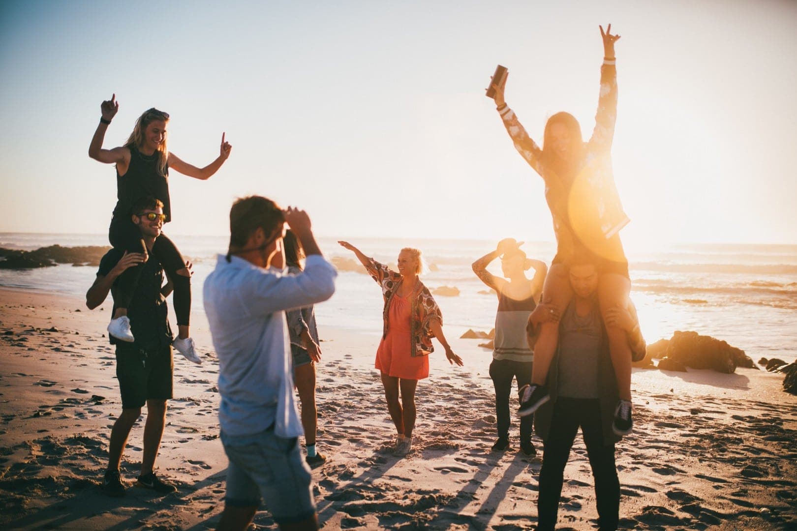 Duża grupa młodych ludzi dobrze bawią się na plaży o zachodzie słońca, Zakynthos, Grecja, wycieczki fakultatywne