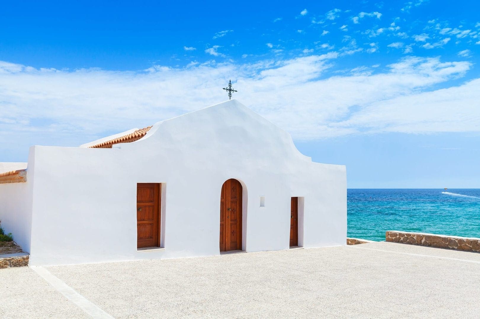 Biały kościół Agios Nikolaos Zakynthos na plaży Agios Nikolaos (Świętego Mikołaja) na półwyspie Vassilikos na Zakynthos, w słoneczny dzień, podczas wycieczek lokalnych z przewodnikiem Zakynthos