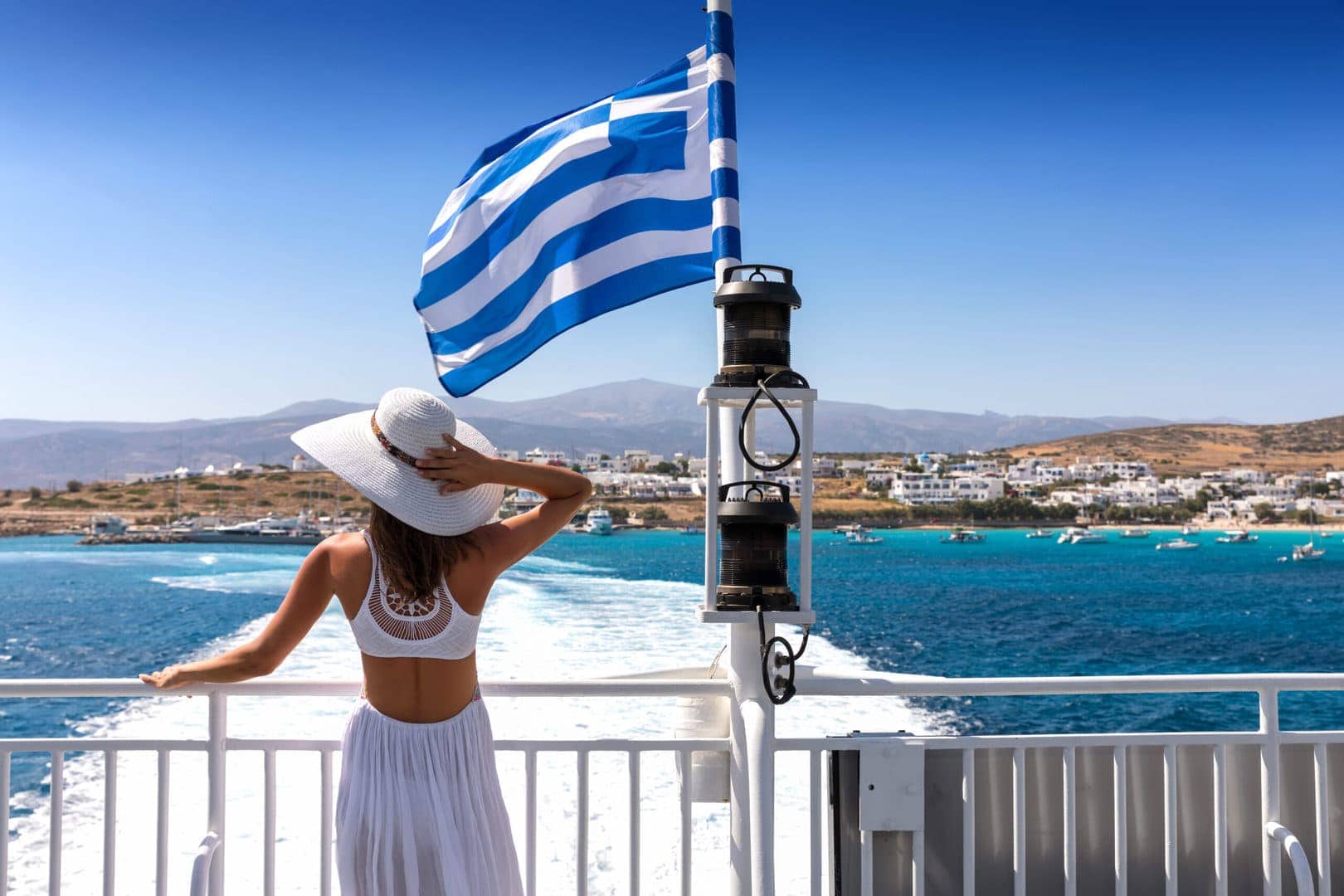 Prom Kefalonia-Zakynthos, grecka flaga powiewająca na wietrze, podczas przeprawy promowej z Kefalonii na Zakynthos, podczas wycieczki lokalnej na wyspie Kefalonia z przewodnikiem