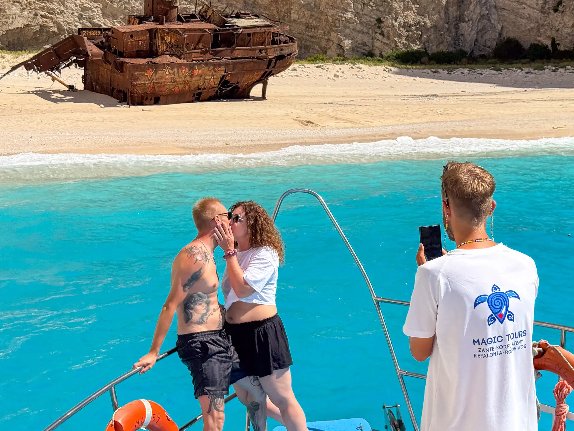 Para całująca się na pokładzie statku Magic Tours z widokiem na wrak statku Panagiotis na plaży Navagio na Zakynthos.