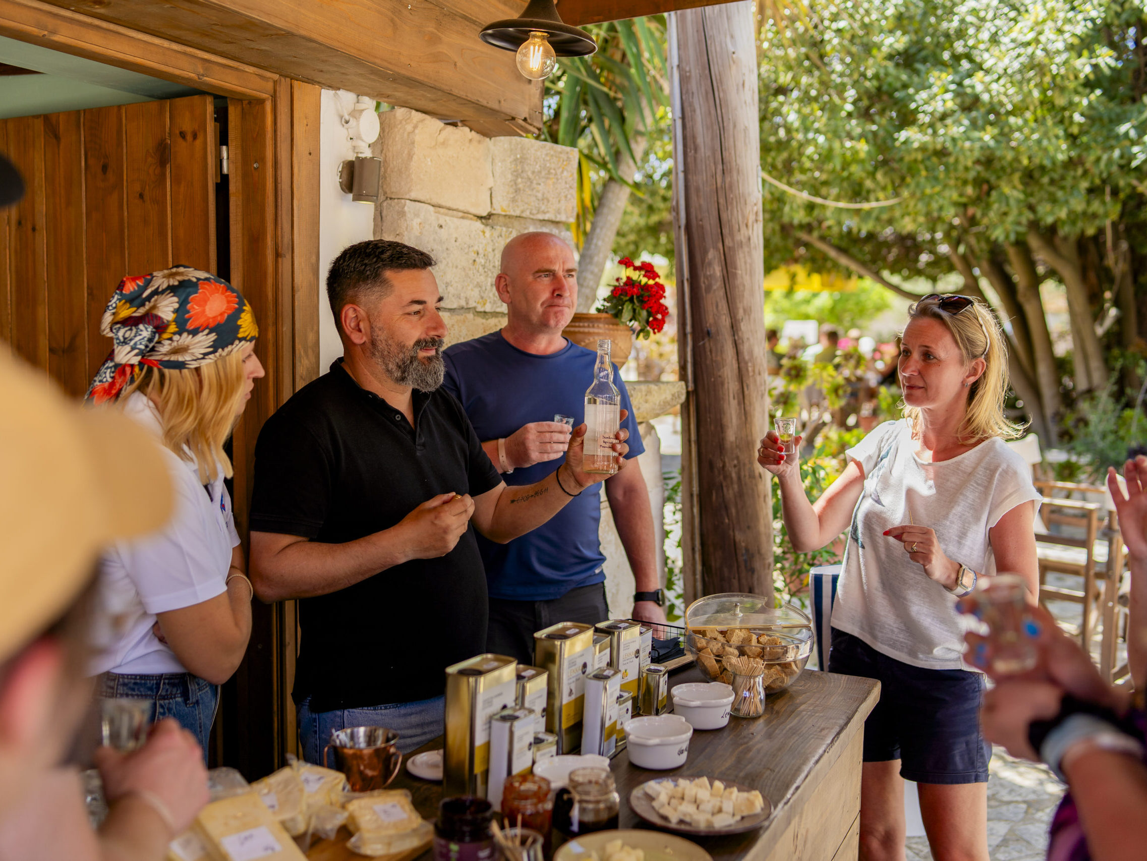 Turyści degustują lokalne produkty – oliwę, sery i nalewki – podczas wizyty na Lekkas Farm na Zakynthos.