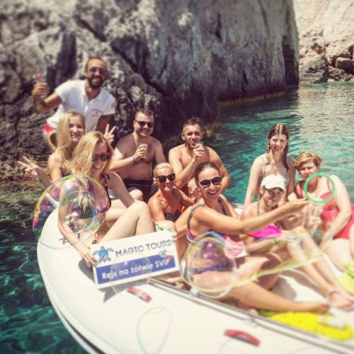 Grupa szczęśliwych ludzi na małej łodzi motorowej podczas rejsu na Zakynthos w poszukiwaniu żółwi Caretta caretta ekskluzywną motorówką